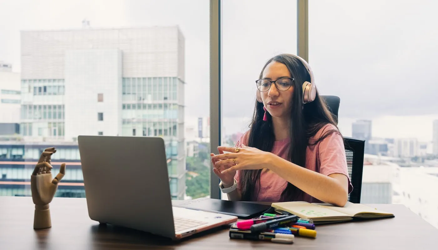 Professional on a video call with headphones in a modern workspace
