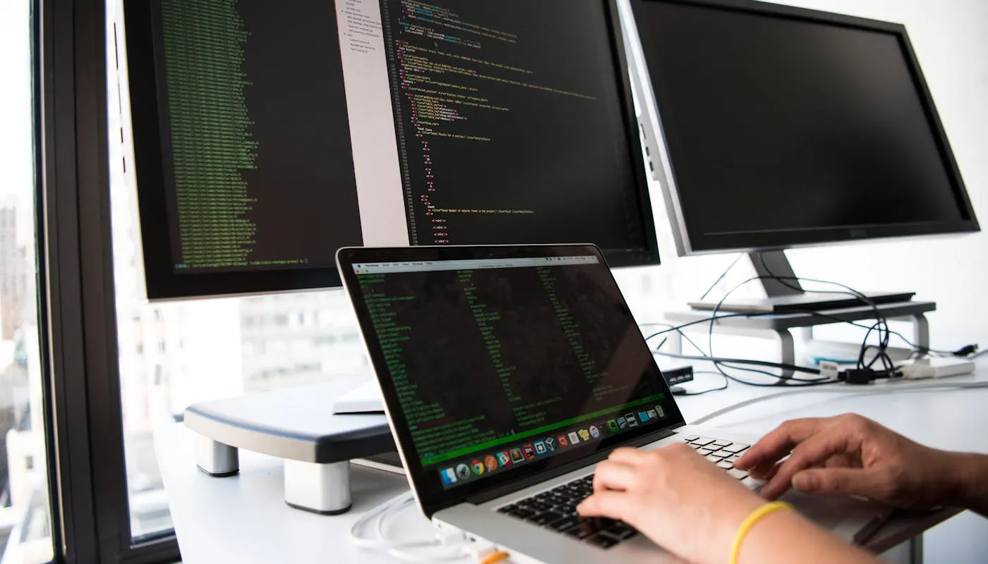 Developer working with multiple monitors in an office