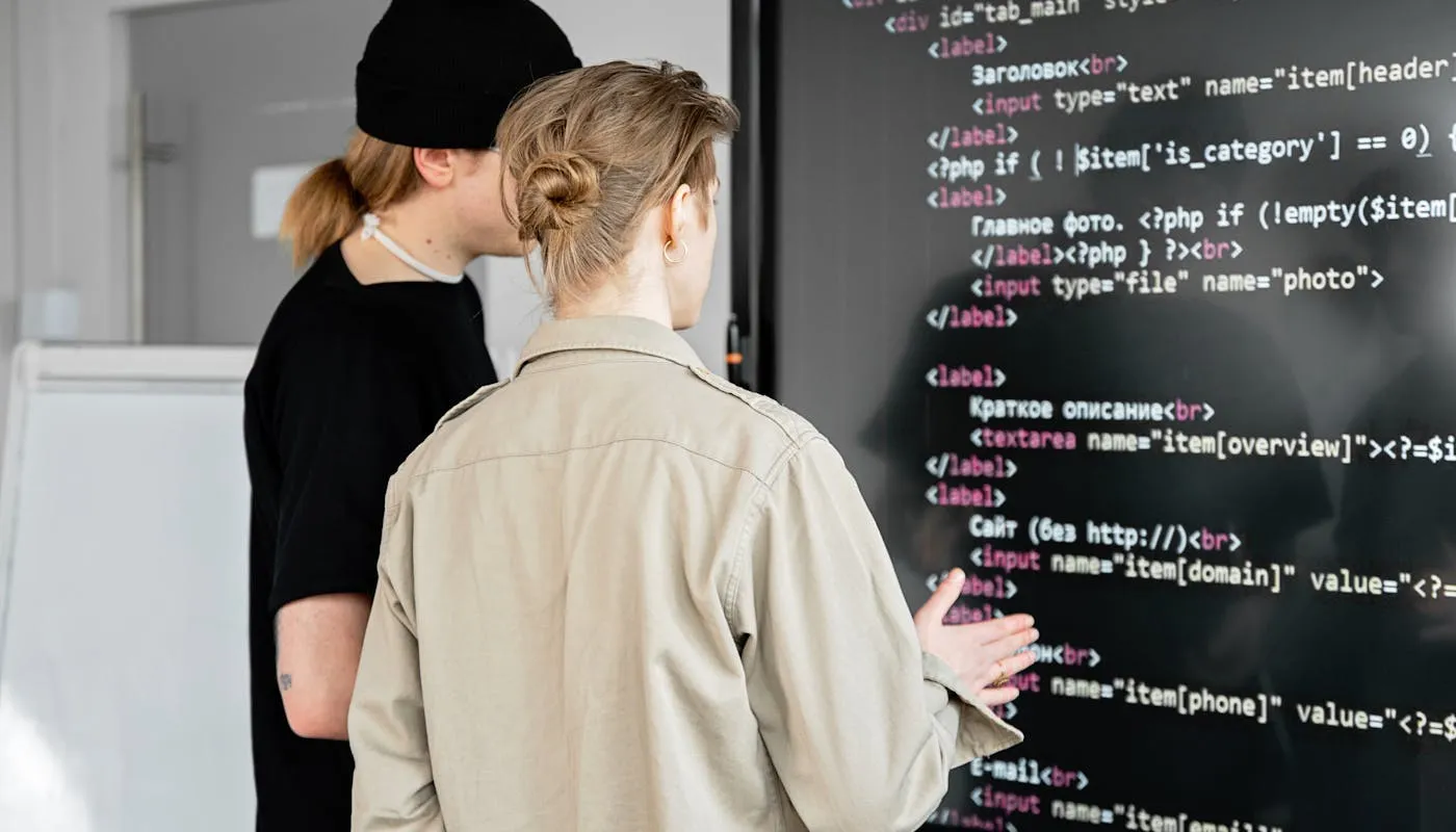 Developers reviewing code on a large screen in a modern office