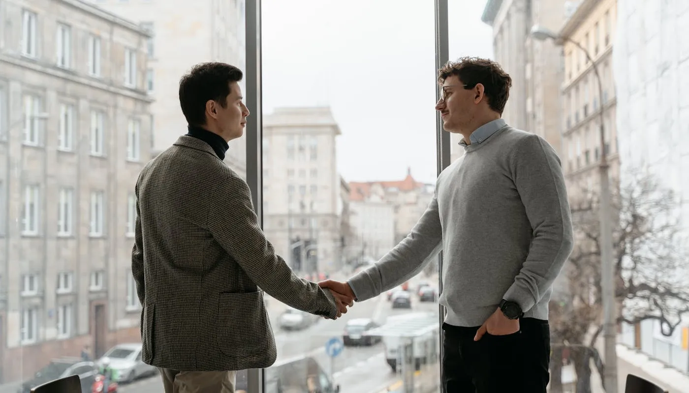 Business professionals shaking hands in a modern office with city view